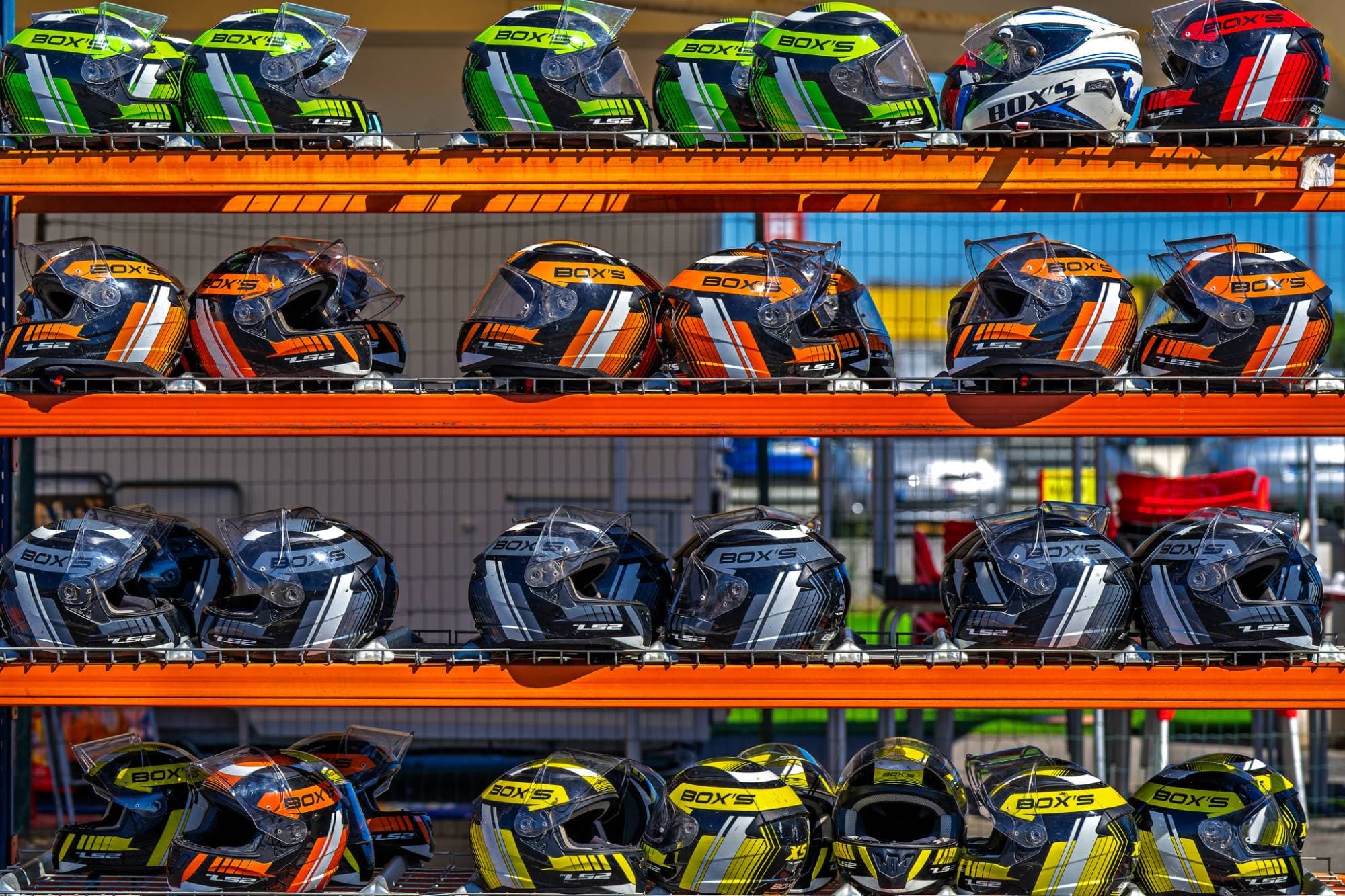 Les casques du circuit alignés sur les étagères du stand
