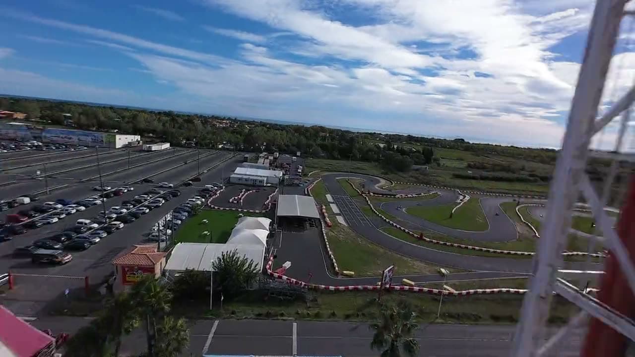 Vol de drone au ras de la piste du circuit MegaKart, kart en pleine courbe